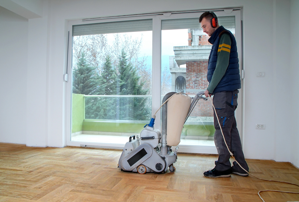 Sanding parquet with the grinding machine. Polishing, repair in apartment